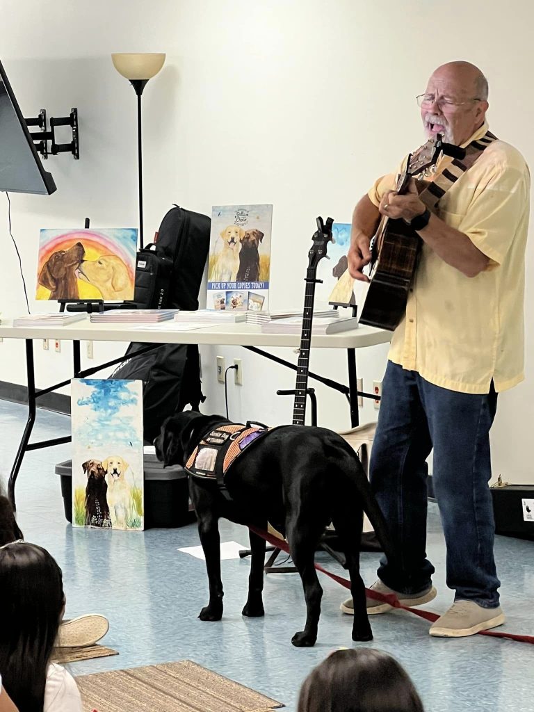 Musician Aaron Fowler came to the library with his a trained therapy dog on Thursday, June 20th to present his “The Adventure Begins Today!” Summer Reading program.