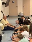 Musician Aaron Fowler came to the library with his a trained therapy dog on Thursday, June 20th to present his “The Adventure Begins Today!” Summer Reading program.